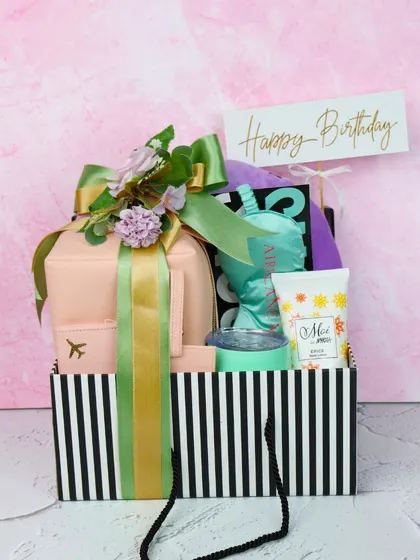 The ultimate birthday hamper, packed with personalized travel essentials and pampering treats. This gift set, presented in a stylish striped bag, is sure to make their day brighter.