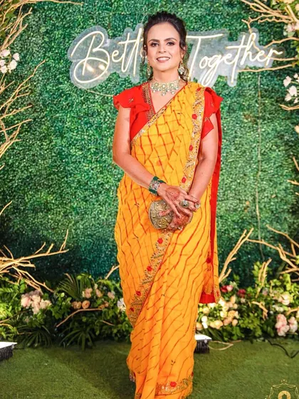 A vibrant and fun party makeup look. The client's bright yellow saree is complemented by fresh, glowing makeup that makes her look ready to celebrate.