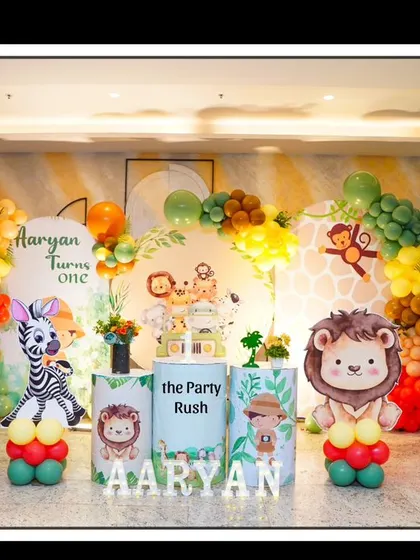 A different angle of Aaryan's jungle-themed first birthday, showcasing the cute lion and zebra balloon sculptures and the overall festive atmosphere.