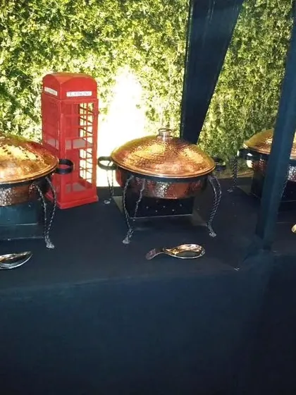A themed buffet setup featuring a miniature red telephone booth as a prop, adding a fun and quirky touch to this London-themed event corner.