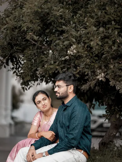 A quiet moment shared between a couple under a tree, showcasing a simple and natural style of portraiture.