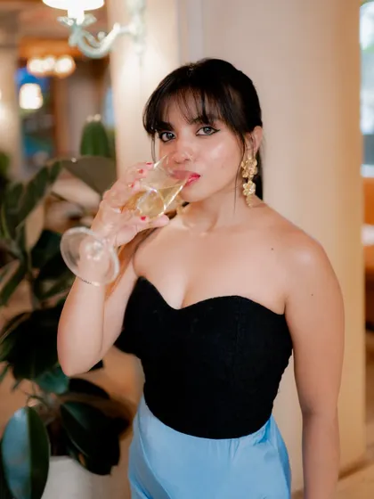 A close-up portrait of a model drinking from a champagne glass. This shot is elegant and captures a celebratory, sophisticated moment.