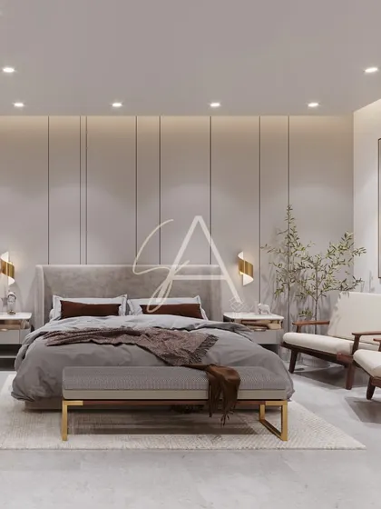 The combination of a soft, upholstered bed, minimalist wooden armchairs, and warm lighting creates a balanced and serene bedroom. The vertical wall paneling adds a subtle, modern texture.
