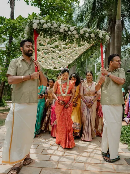 The bride's grand entrance under a beautiful floral canopy. This shot captures the tradition and elegance of a Telugu wedding ceremony.