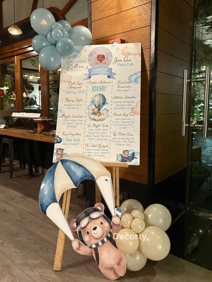 A personalized milestone board for the birthday boy, Ridhav, detailing his 'flight path' through his first year. This is a wonderful way to share special memories with guests.