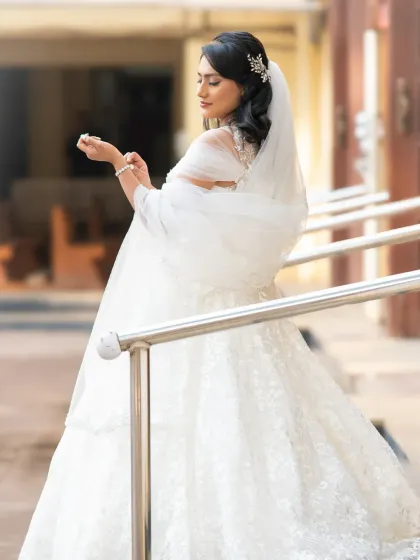 An elegant and candid-style bridal portrait. The soft light and the bride's pose create a graceful and timeless image.