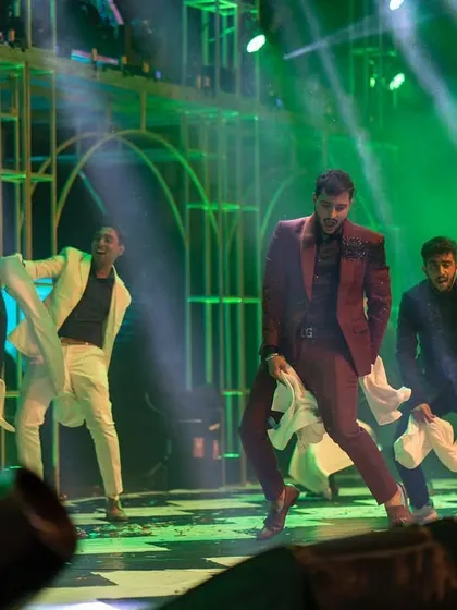 A powerful groom's performance with his friends, using handkerchiefs as props for a classic, coordinated look. The energy on stage is absolutely infectious.