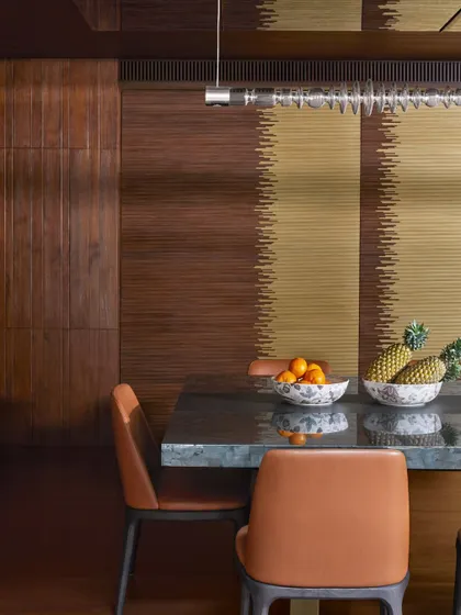 A fluted door made of brass and wood at the Baid Residence. The vertical lines of the fluting create a beautiful textural pattern, and the combination of metal and wood adds a layer of sophisticated warmth.