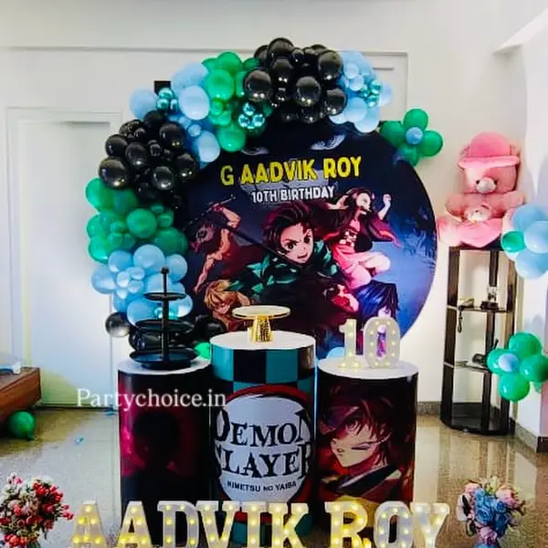 A Demon Slayer tenth birthday at home: a round print with the name and 10th Birthday in a black, green and blue garland, three plinths in the show's prints, a lit 10 and the name in lit letters