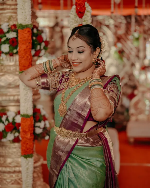 A beautiful South Indian bride adjusting her jewelry, a classic and elegant portrait from her wedding day.