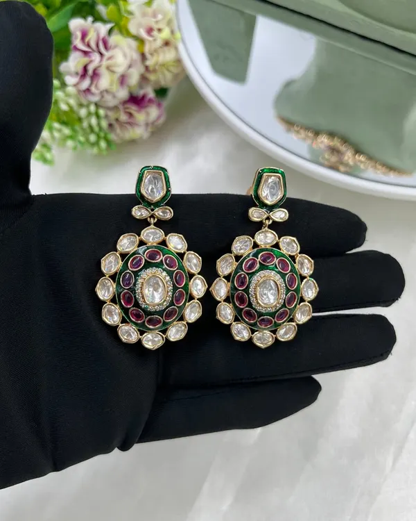 A pair of stunning oversized earrings with green and red Meenakari work, set with Moissanite stones. These are perfect as standalone statement pieces.