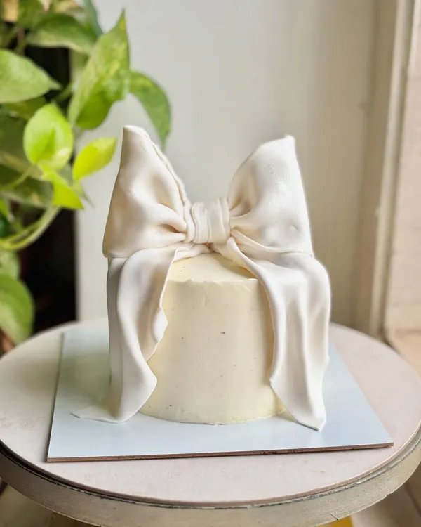 It’s fondant, not fabric, but you’d never know. This signature bow cake is a little moment of cake couture, perfect for when you want a piece that is minimal, modern, and absolutely unforgettable. 🤍✨