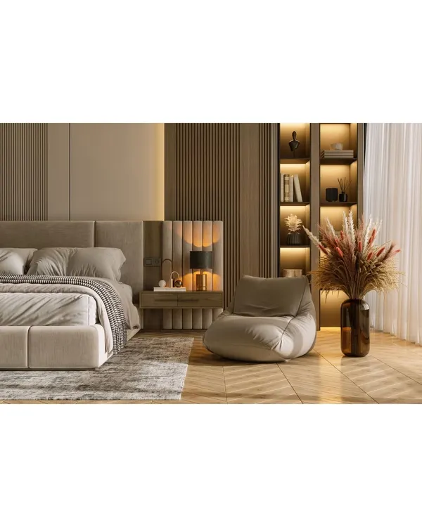 A luxurious bedroom featuring a floor-to-ceiling upholstered and wood-paneled headboard. The integrated bedside lighting and built-in bookshelf create a cozy and functional reading nook.