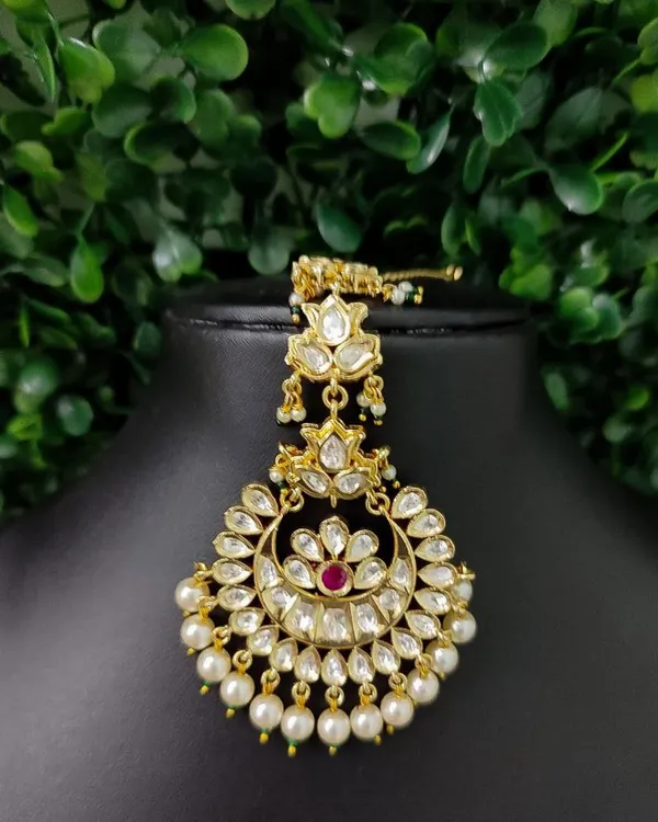 A classic and elegant kundan maang tikka with a crescent design, surrounded by pearls. This is one of my most popular rental pieces.
