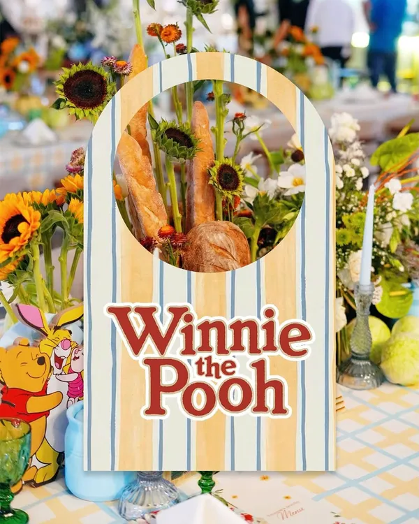 A custom sign for a Winnie the Pooh themed party, with a unique centerpiece combining fresh baguettes and sunflowers.