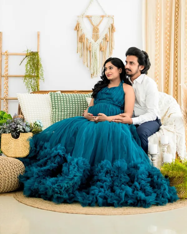 A serene moment between an expecting couple in our boho-themed studio. The beautiful teal gown is one of many options available from our client wardrobe for your maternity session.