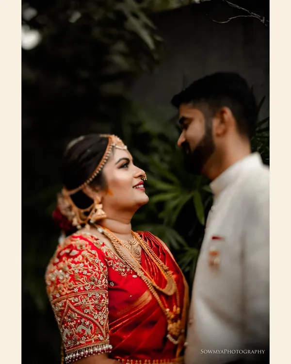 A quiet moment of connection between the bride and groom. The intricate embroidery on her blouse and the soft look they share make this a timeless South Indian wedding portrait.