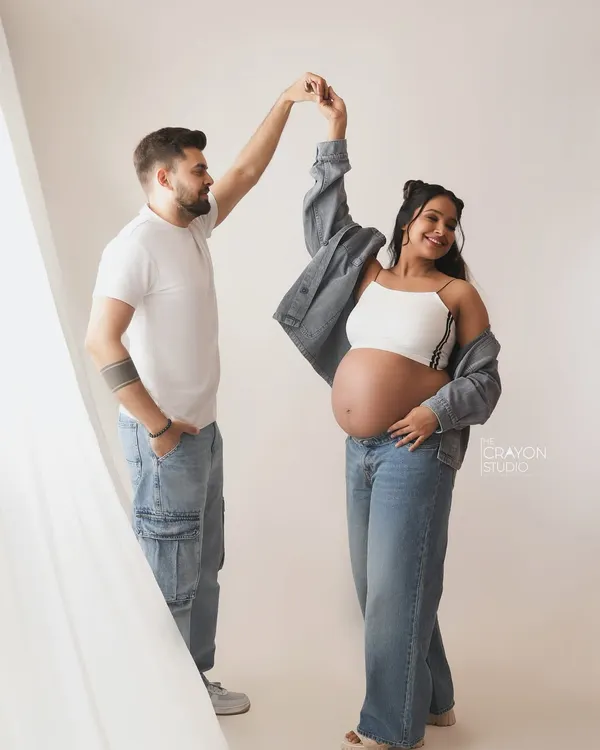 A fun, spontaneous dance in the studio. This casual denim look is perfect for couples who want their maternity photos to reflect their modern, playful style.
