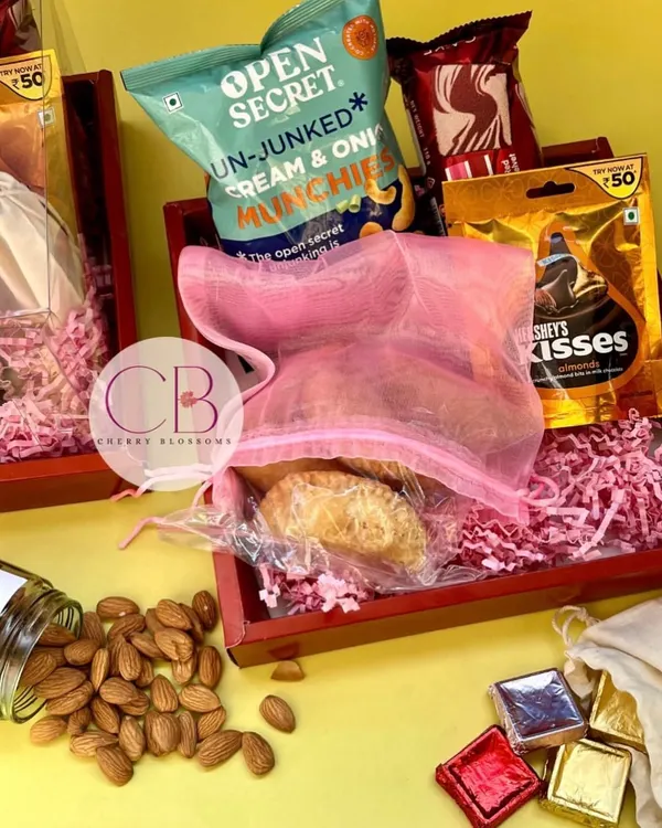 These Roka return favours are a perfect blend of traditional and modern tastes. Each red tray was filled with a jar of almonds, handmade Gujjia, and a mix of branded and homemade chocolates.