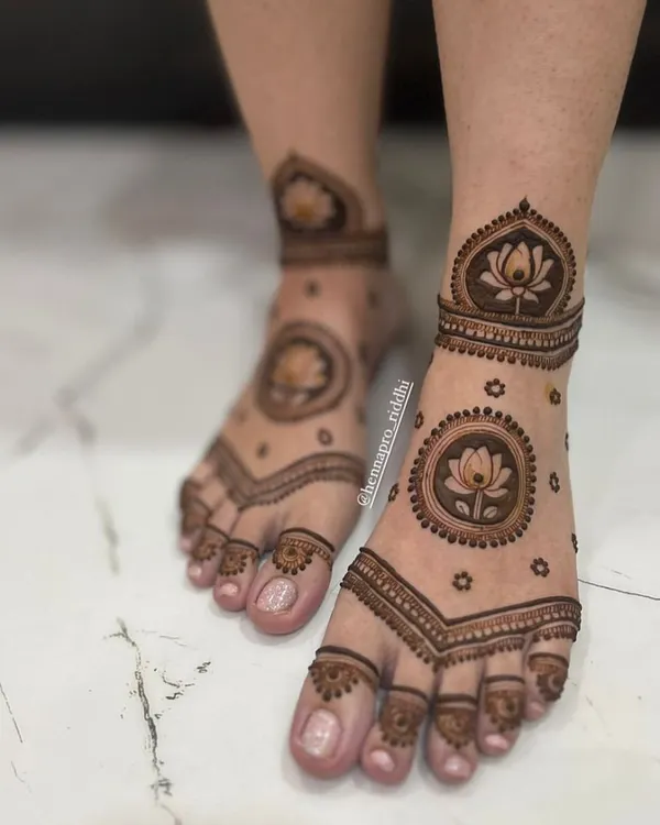 This Pinterest-worthy feet design is a modern favorite. It features a prominent lotus mandala on the top of the foot with delicate surrounding details for a very chic look.