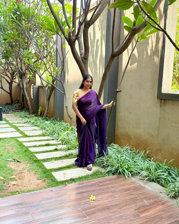 A full shot of my plain purple saree paired with a vibrant, multi-color printed blouse. I love pairing simple sarees with contrast printed blouses. This look, set in a beautiful garden, feels so serene.