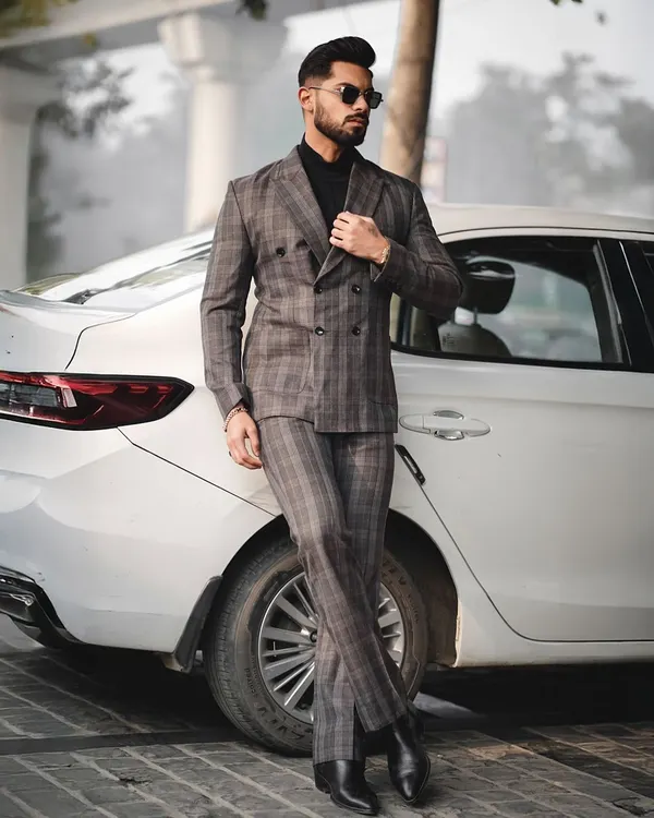 A full-length shot from a men's formal wear series. Posing next to a car adds a lifestyle element to this sharp, tailored look, making it suitable for both fashion portfolios and brand lookbooks.