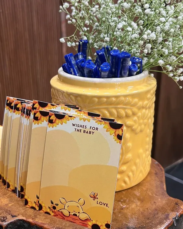 Sweet details for a "Baby in Bloom" shower, including Winnie the Pooh themed "Wishes for the Baby" cards and pens for guests.