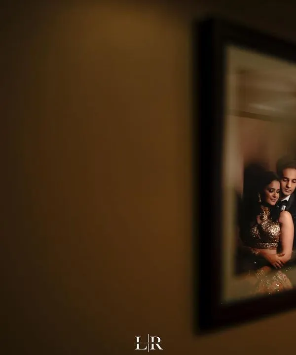 A creative couple portrait captured as a reflection in a framed picture. We love using unconventional angles and compositions to create artistic and memorable shots.