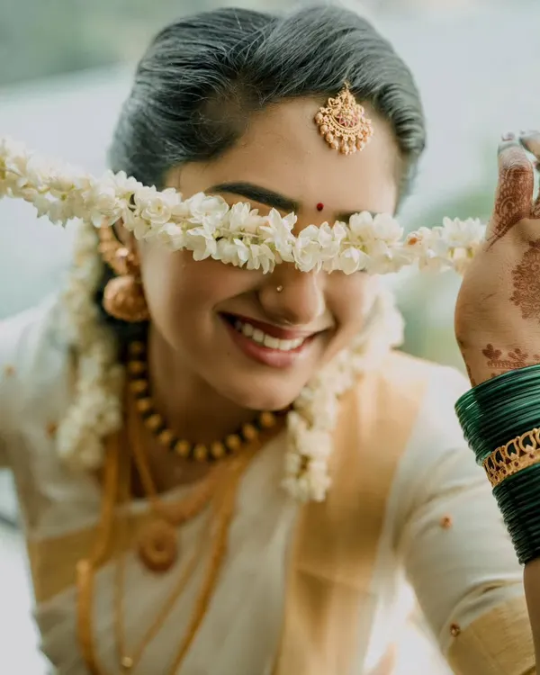 A joyful moment with a South Indian bride, her smile captured through a traditional jasmine garland. This is the kind of candid, beautiful memory I strive to create.