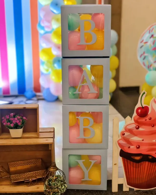 I love creating fun themes like this candyland party. These 'BABY' blocks filled with colorful balls, along with cupcake and donut cutouts, add a playful and sweet touch to the decor.