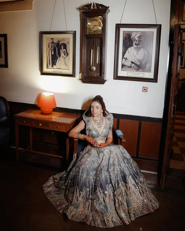 This is a classic, elegant bridal portrait. We teach you how to use a single light source to sculpt the subject, creating soft shadows that highlight her features and the texture of her lehenga. The composition is centered and formal, fitting the royal venue.