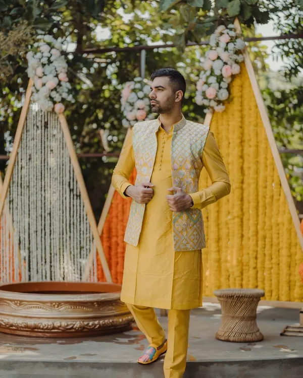 A stylish portrait of the groom during his Haldi ceremony. The vibrant yellow kurta perfectly complements the marigold decor, and my photography captures his confident and happy demeanor.