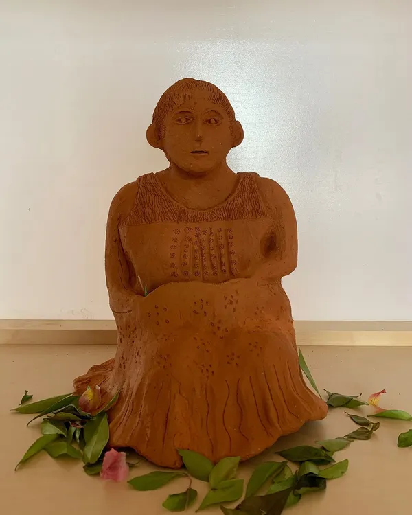 In the gentle rhythm of clay, we find solace. This terracotta sculpture captures a quiet, soulful moment.