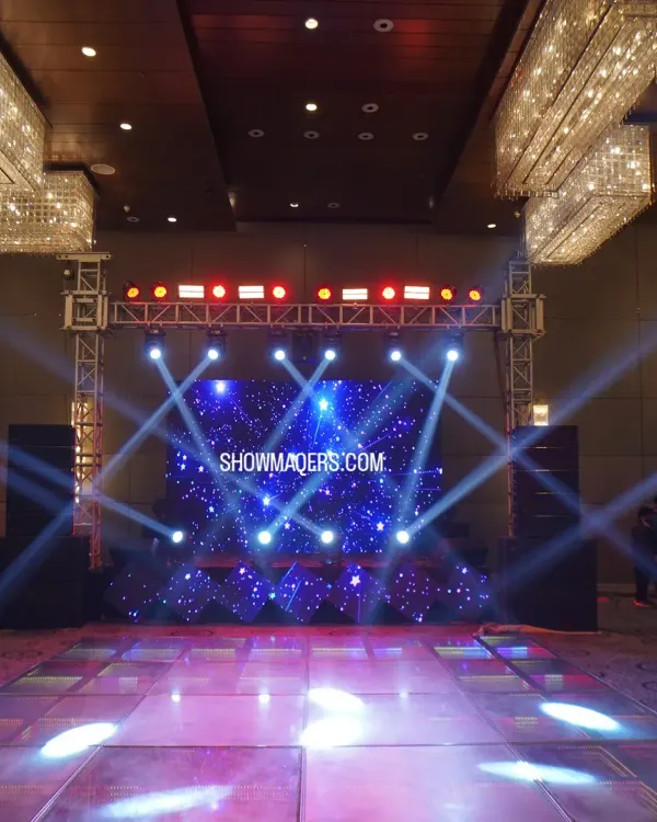 A professional stage and dance floor setup with an LED screen displaying a starry night graphic, perfect for a Sangeet or reception.