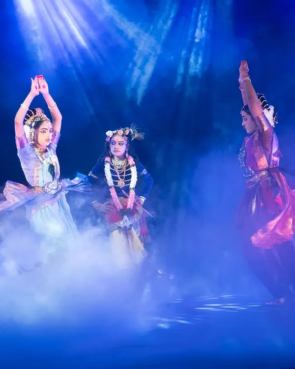A scene from "KRISHNA" where dancers are enveloped in ethereal blue light and mist, creating a dreamlike vision of the divine world. This is a testament to our collaboration with expert lighting designers to craft each moment.