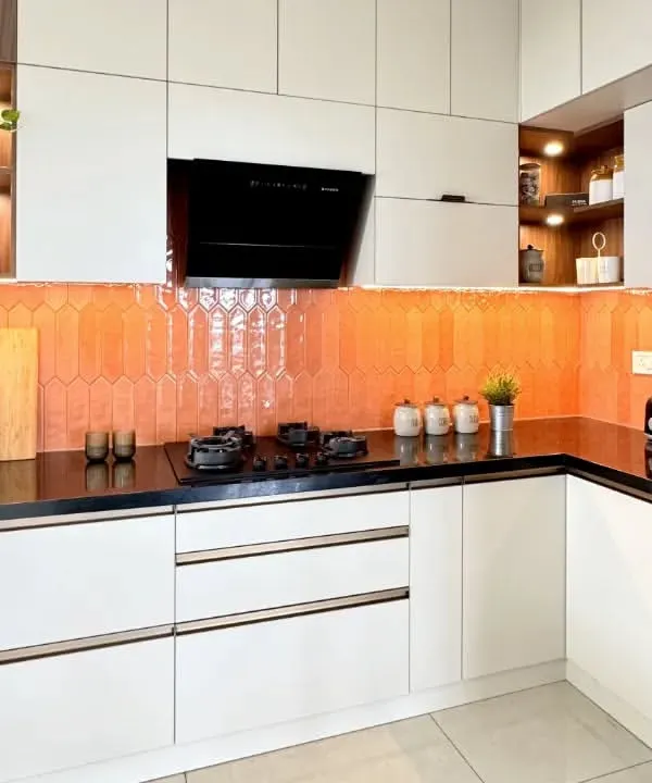 This kitchen is all about bringing warmth and style with a vibrant orange picket tile backsplash. I paired it with neutral white cabinets and a black granite countertop to create a balanced and cheerful cooking space.