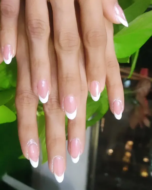 A timeless classic. This is the traditional French manicure with clean, crisp white tips on beautifully shaped almond nails, perfect for an elegant and polished look.