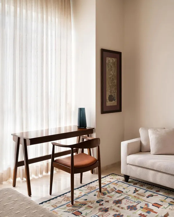 This study corner features a custom-designed desk and armchair in dark wood with a leather seat. The pieces are crafted to be elegant and functional, creating a peaceful nook for work or contemplation within the master bedroom.