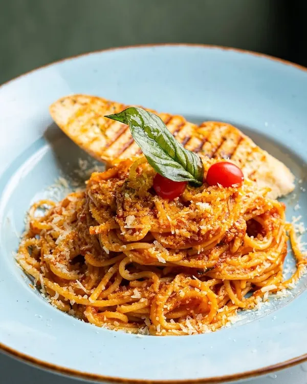 A timeless classic, done right. Our Nonna’s Tomato Basil Spaghetti is a crowd-pleaser, made with a rich, slow-cooked tomato sauce, fresh basil, and a generous sprinkle of parmesan, served with grilled garlic bread.