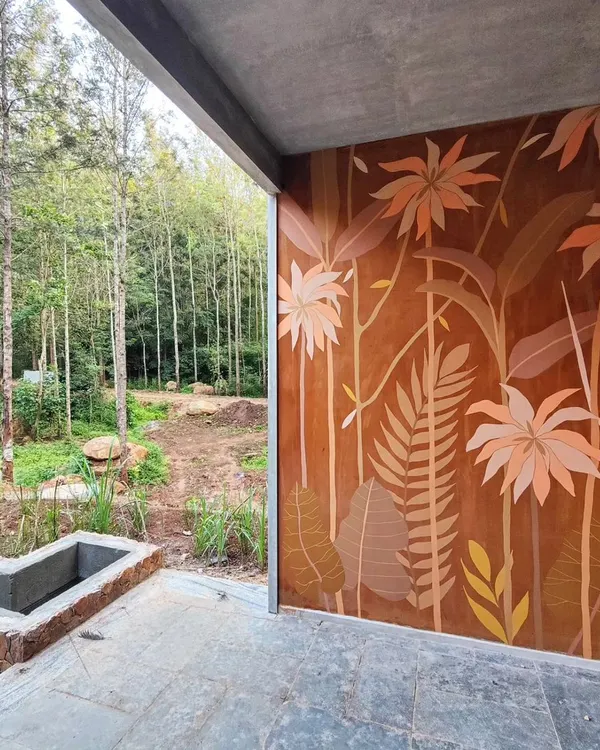 This tropical mural on a warm, terracotta-colored wall is designed to complement the surrounding forest, blurring the line between inside and out.