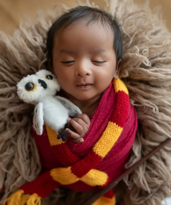 Our little wizard is dreaming of magical adventures. This close-up shows him cuddling a tiny Hedwig, a perfect detail for this Harry Potter themed newborn shoot.