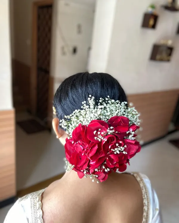 A classic bridal bun made perfect with a combination of vibrant red roses and delicate baby's breath. This is a timeless and elegant choice for any wedding day.
