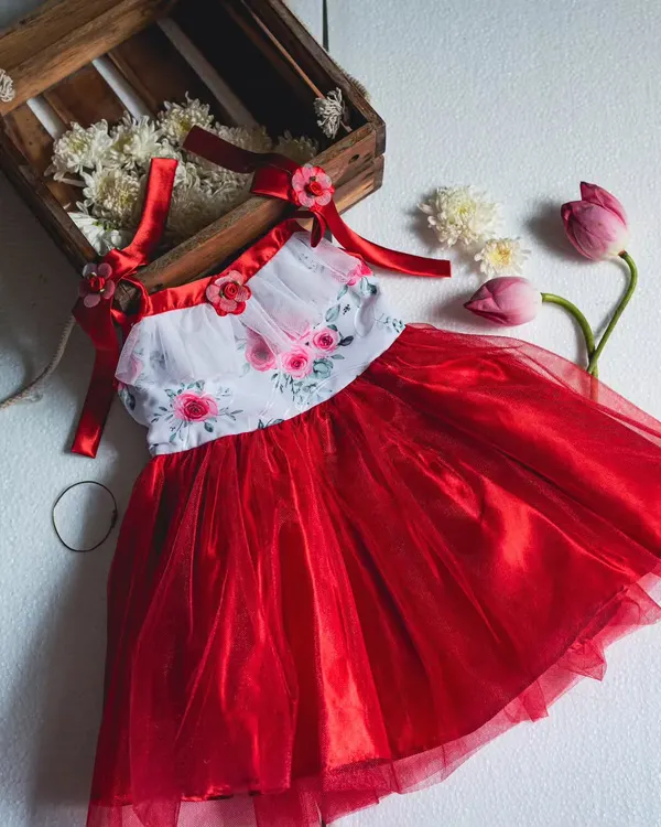 A beautifully styled shot of one of my favorite red and white floral dresses. The combination of the floral print, red tulle, and satin ribbon straps creates a truly romantic and festive look.