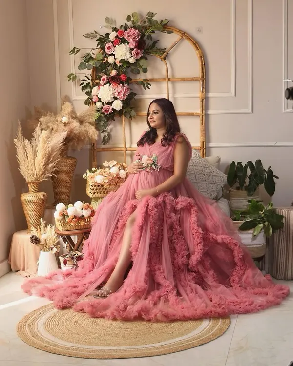 This is the heart of what I do. I create a space where you can feel like a queen, surrounded by beauty that reflects your own inner glow. This mama is radiant in a magnificent pink ruffled gown, set against our dreamy boho-floral studio backdrop.