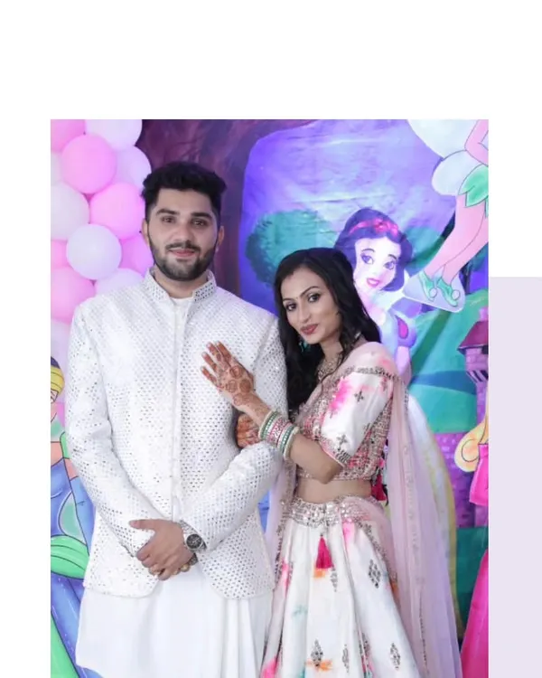 A classic combination for any daytime function. The bride-to-be is in a lovely floral print lehenga, perfectly complemented by the groom's elegant white mirror-work Indo-Western outfit.