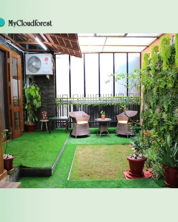 This semi-covered terrace is a complete outdoor room. I combined soft artificial grass with a wicker seating area, a lush vertical garden on one wall, and a thatched roof element to create a cozy, protected space that can be enjoyed in any weather.