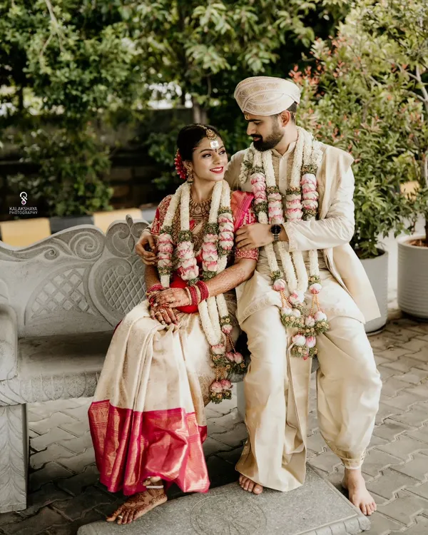 A classic portrait of the bride and groom in their traditional South Indian wedding attire, sharing a quiet moment together.