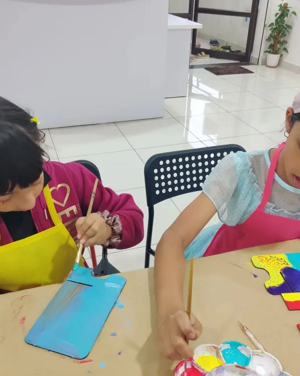 Kids working on their personalized desk calendars. This is a great activity that combines painting with a useful item they can keep all year.