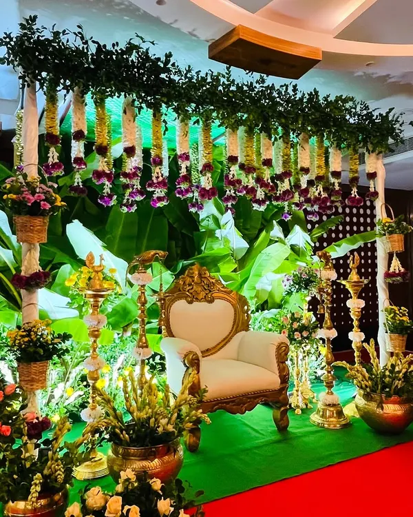 This is my signature South Indian Seemantham setup. I use fresh banana leaves for that lush green backdrop, complemented by hanging garlands of jasmine and tuberose, and traditional brass lamps to create a sacred, festive glow for your baby shower.