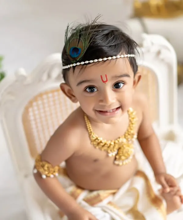 Your little one as a divine little Krishna. This close-up shot captures the innocent smile and bright eyes that make these themed sessions so magical and memorable.